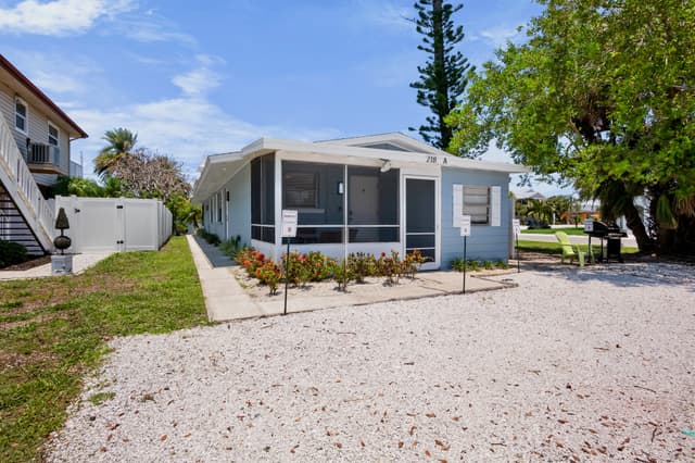 Exterior view of the home with screened lanai and dedicated parking.