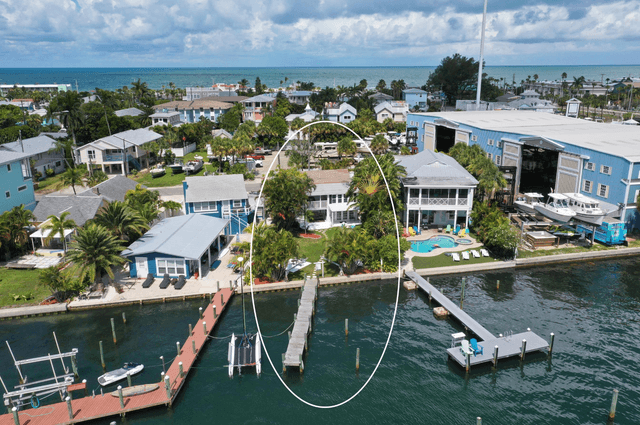 Waterfront property with private dock and pool situated on calm turquoise waters in charming coastal neighborhood.