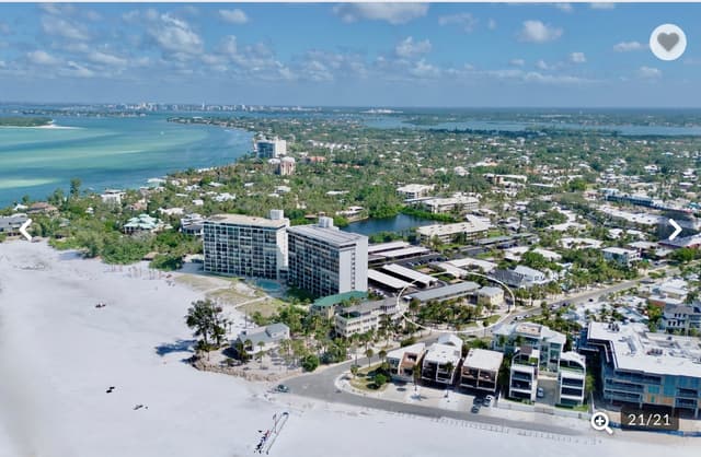 Stunning aerial view of the beachfront property and surrounding coastal community with pristine white sand beaches and turquoise waters.