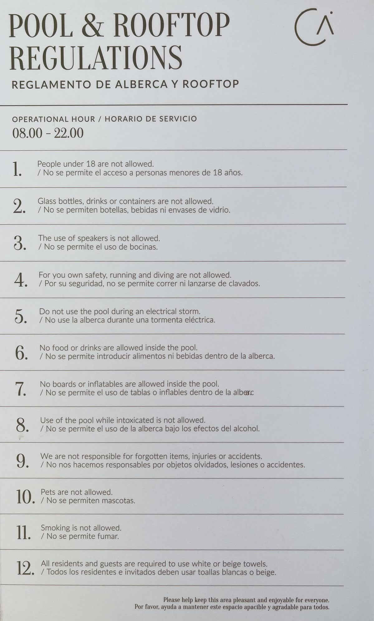 A clear sign detailing 'Pool & Rooftop Regulations' in both English and Spanish, outlining rules such as age restrictions, no glass, no speakers, and no smoking.