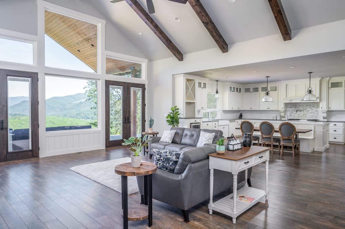Feel right at home in the naturally lit family room with floor-to-ceiling windows and exposed wood beams.
