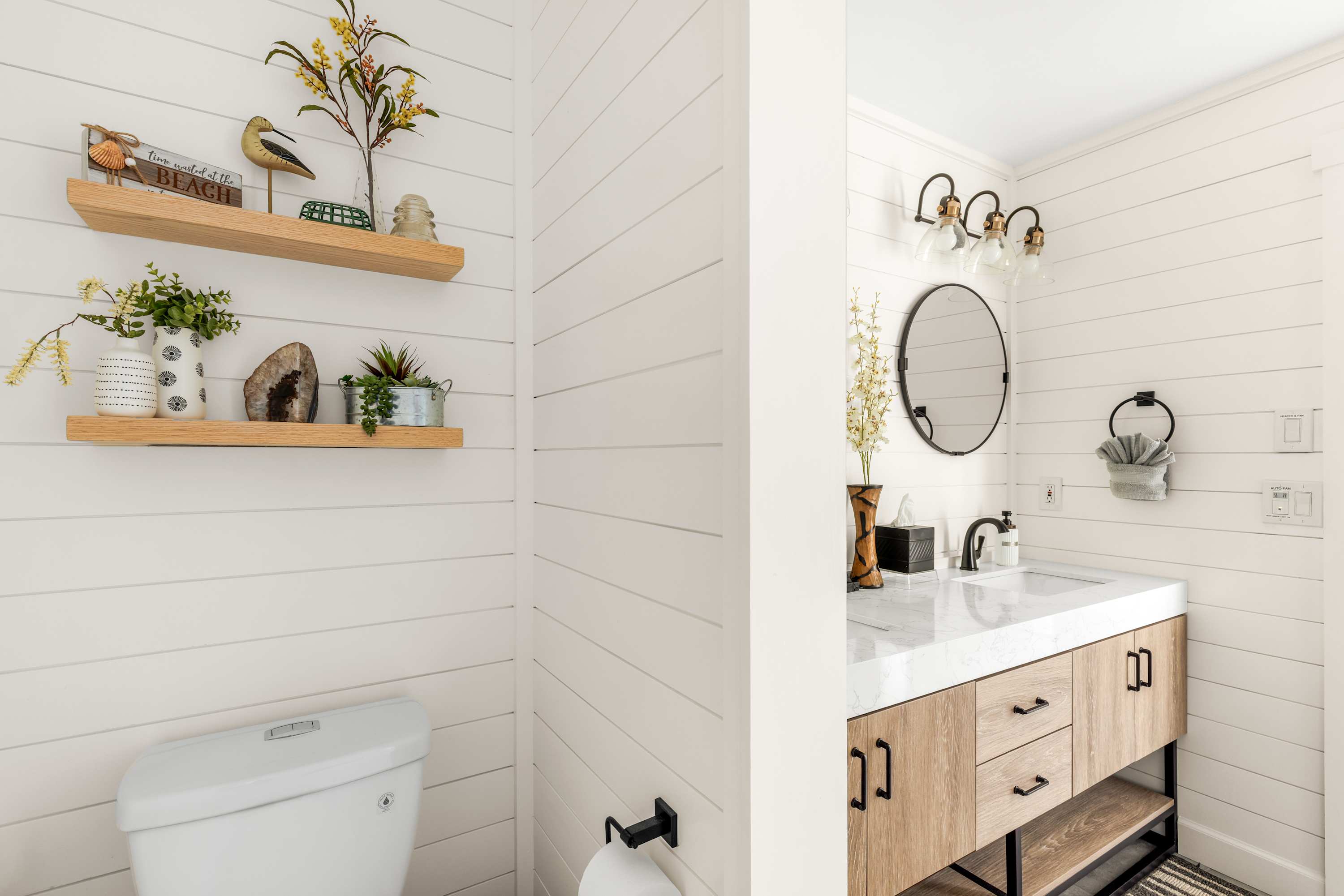 Fresh bathroom space with sleek sink, decorative shelving, and thoughtful design details.