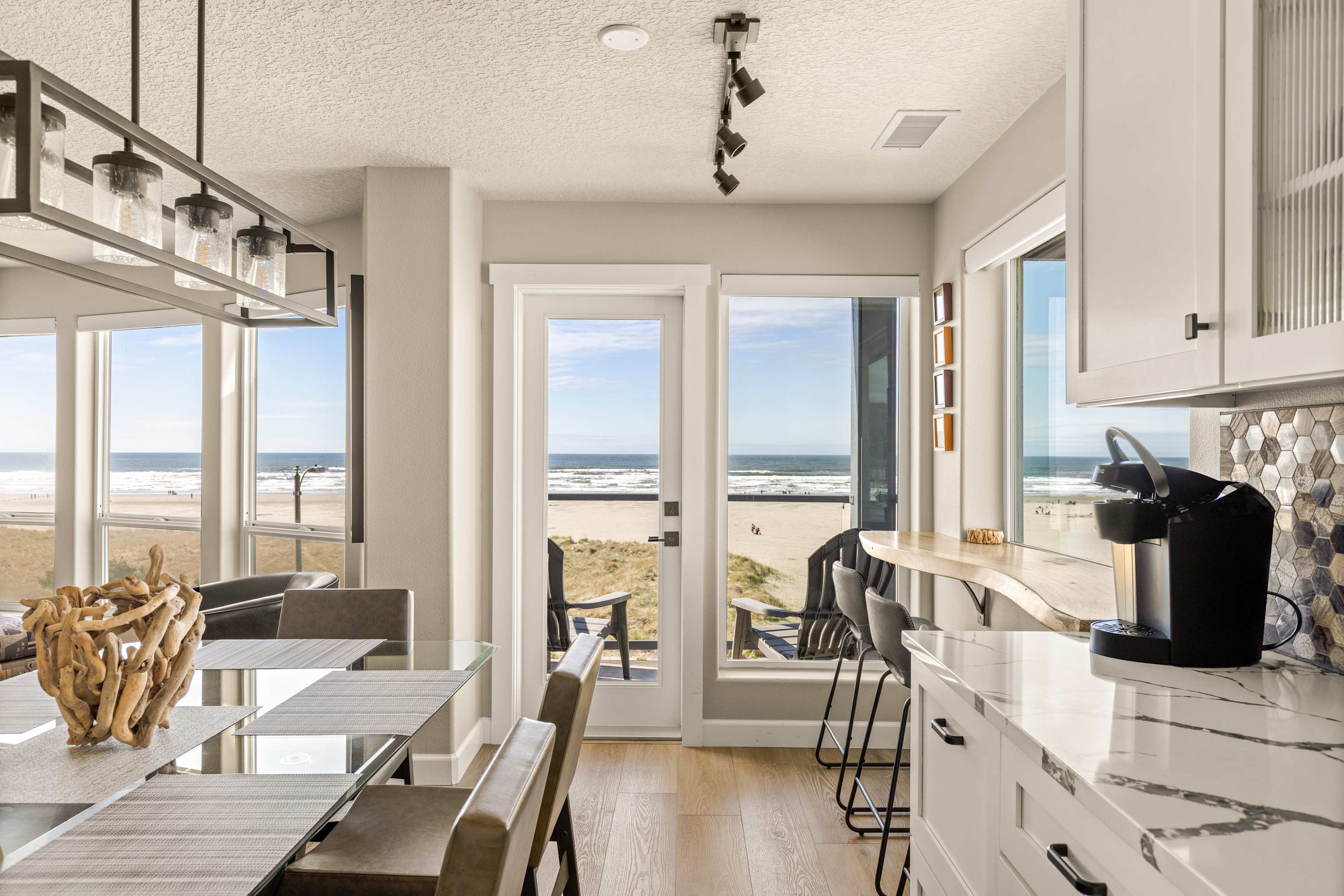 Modern kitchen and dining area with ocean views, breakfast bar, and stylish finishes—perfect for cooking and entertaining.