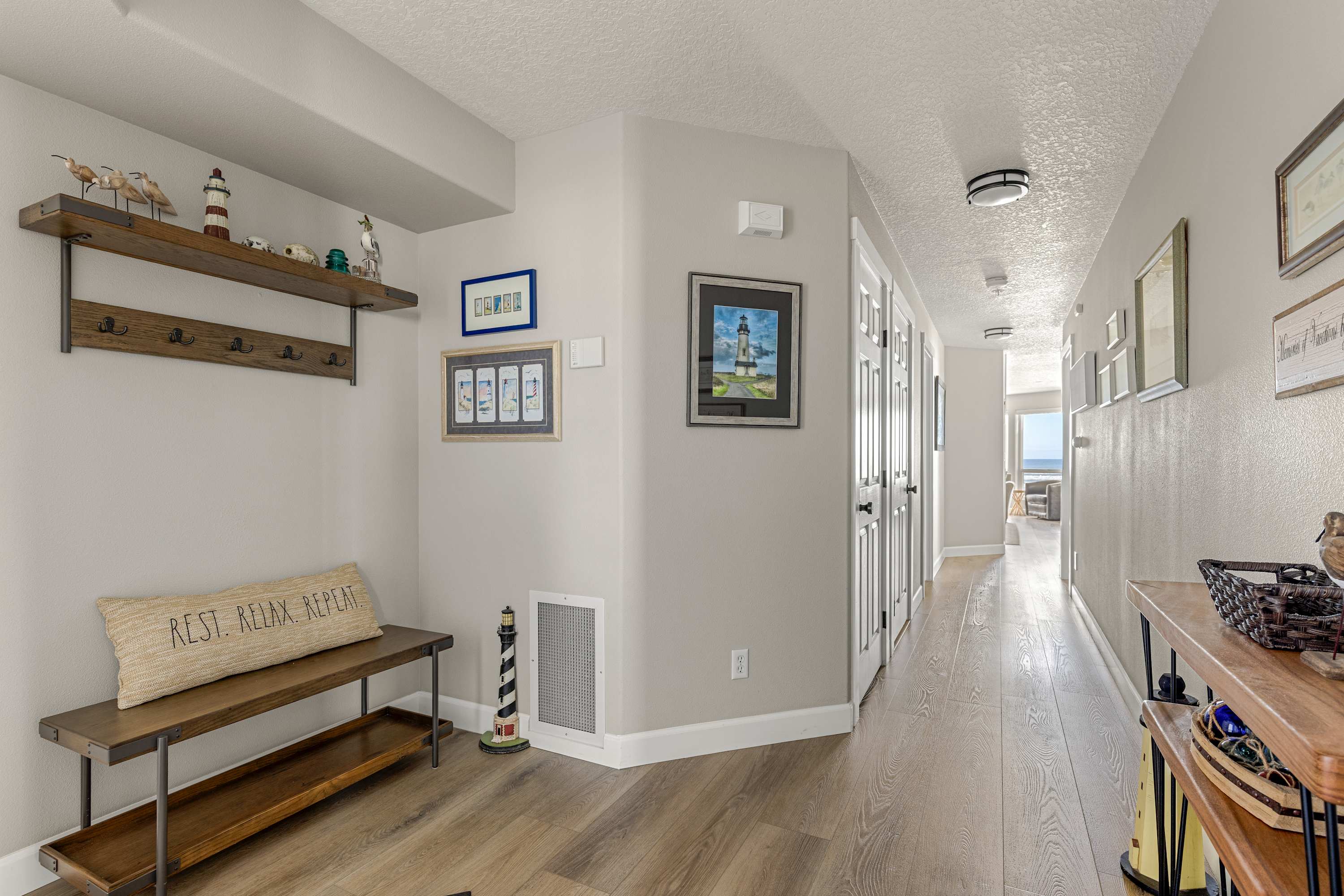 Well-designed hallway with wood floors, coastal accents, and convenient layout connecting all living spaces.