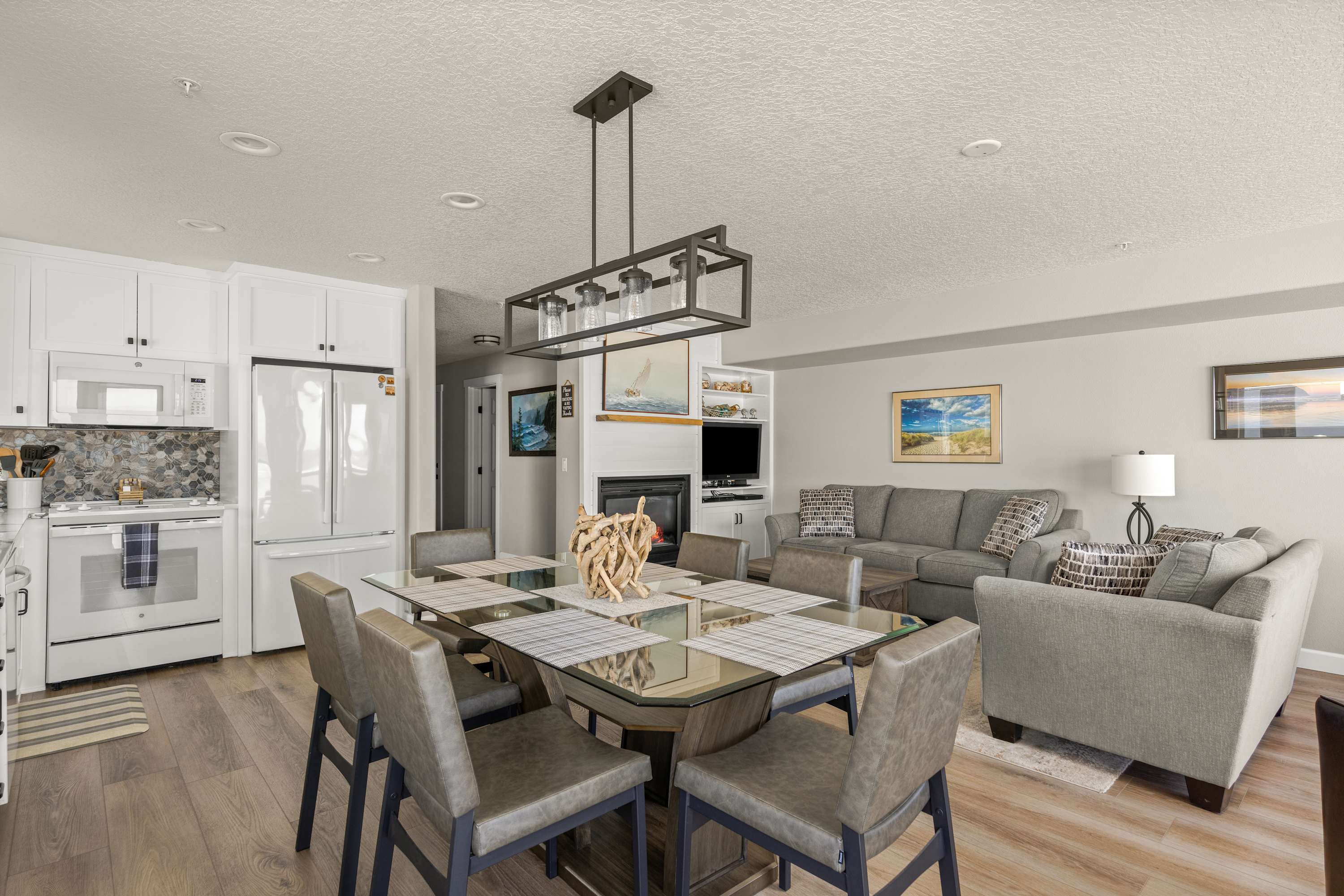 Stylish open-concept living with dining area and fireplace, offering comfort and space for gatherings after a day at the ocean.