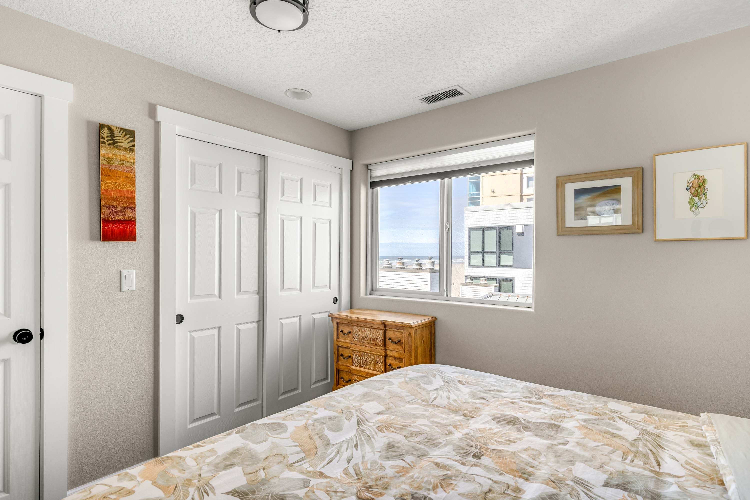 Enjoy a bright, airy bedroom featuring scenic window views and generous closet space for a comfortable stay.