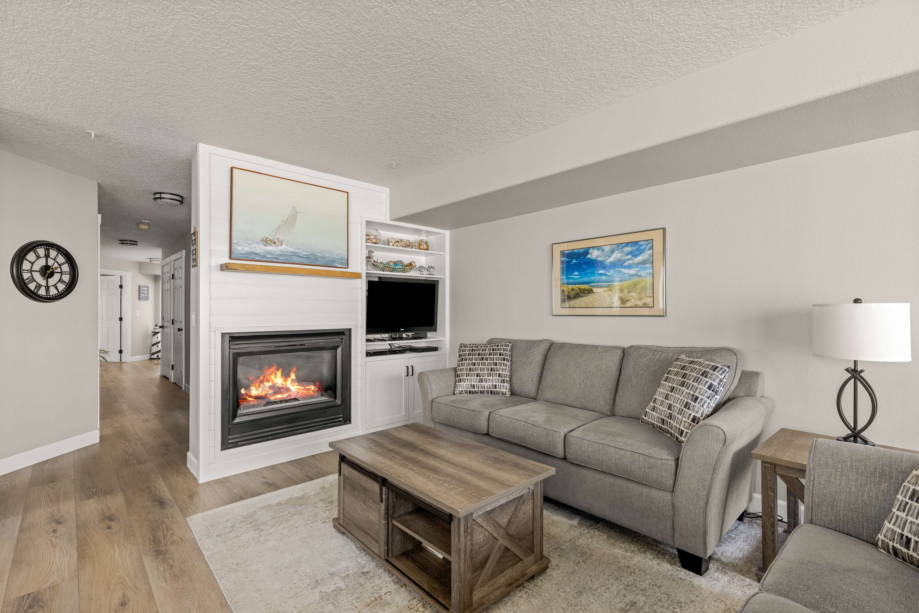 Cozy living room with fireplace, plush seating, and coastal décor—perfect for relaxing after a day at the beach.