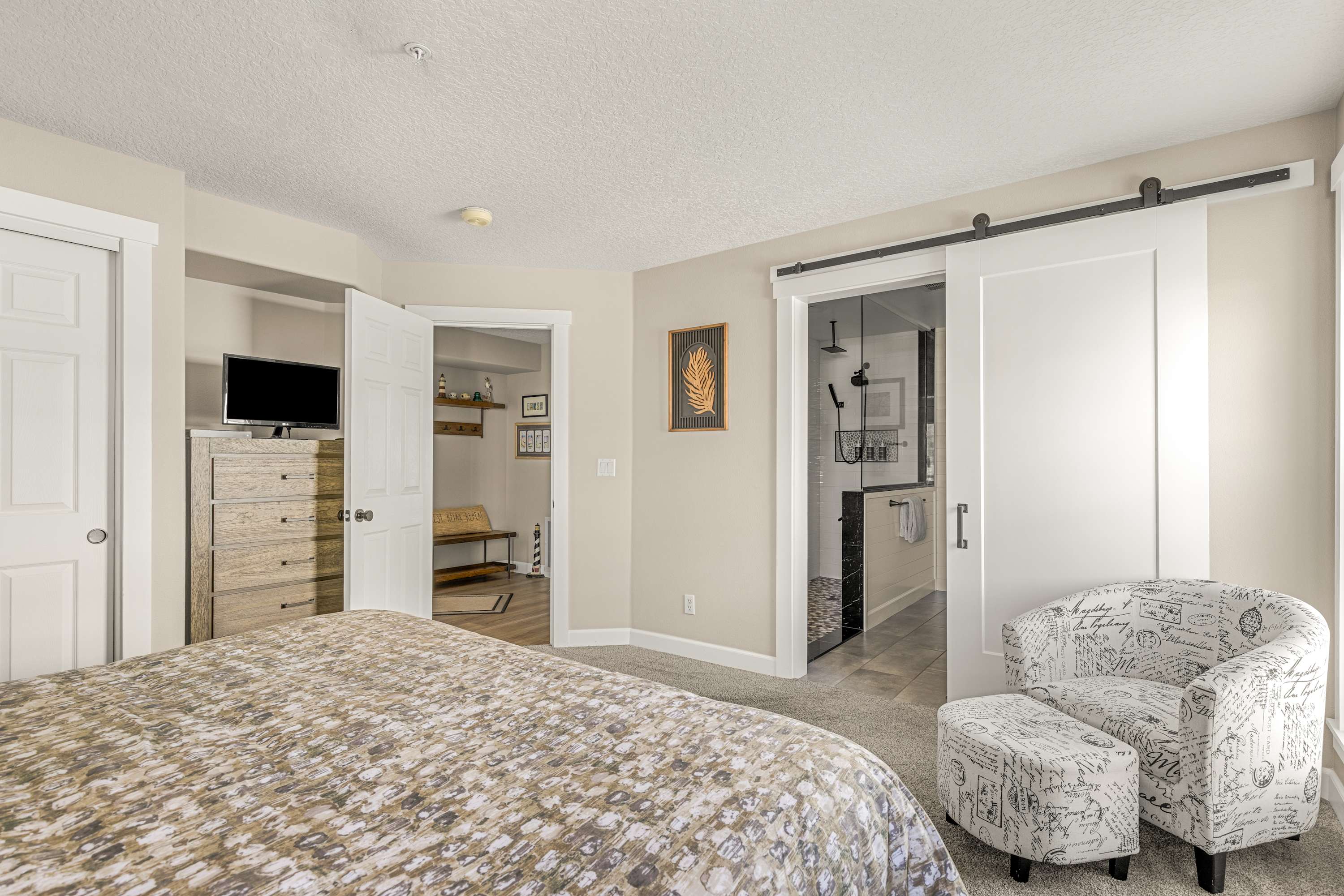 Bright primary suite with private bathroom access, plush seating, and peaceful ambiance for ultimate relaxation.