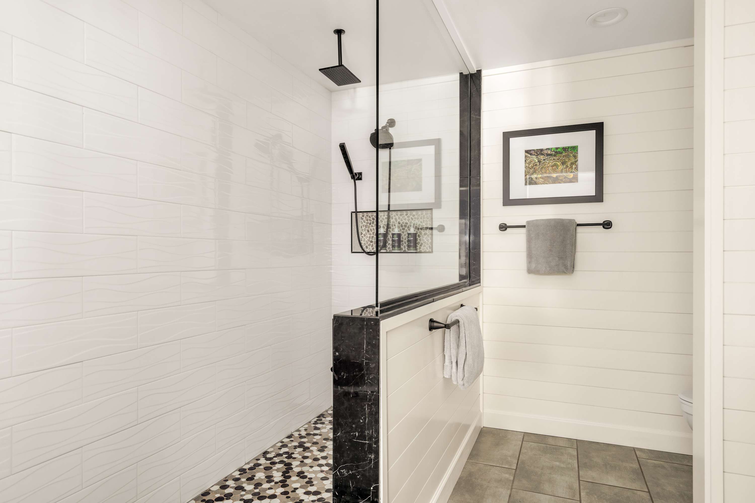 Spacious walk-in shower with glass enclosure, modern tile, and spa-like design.