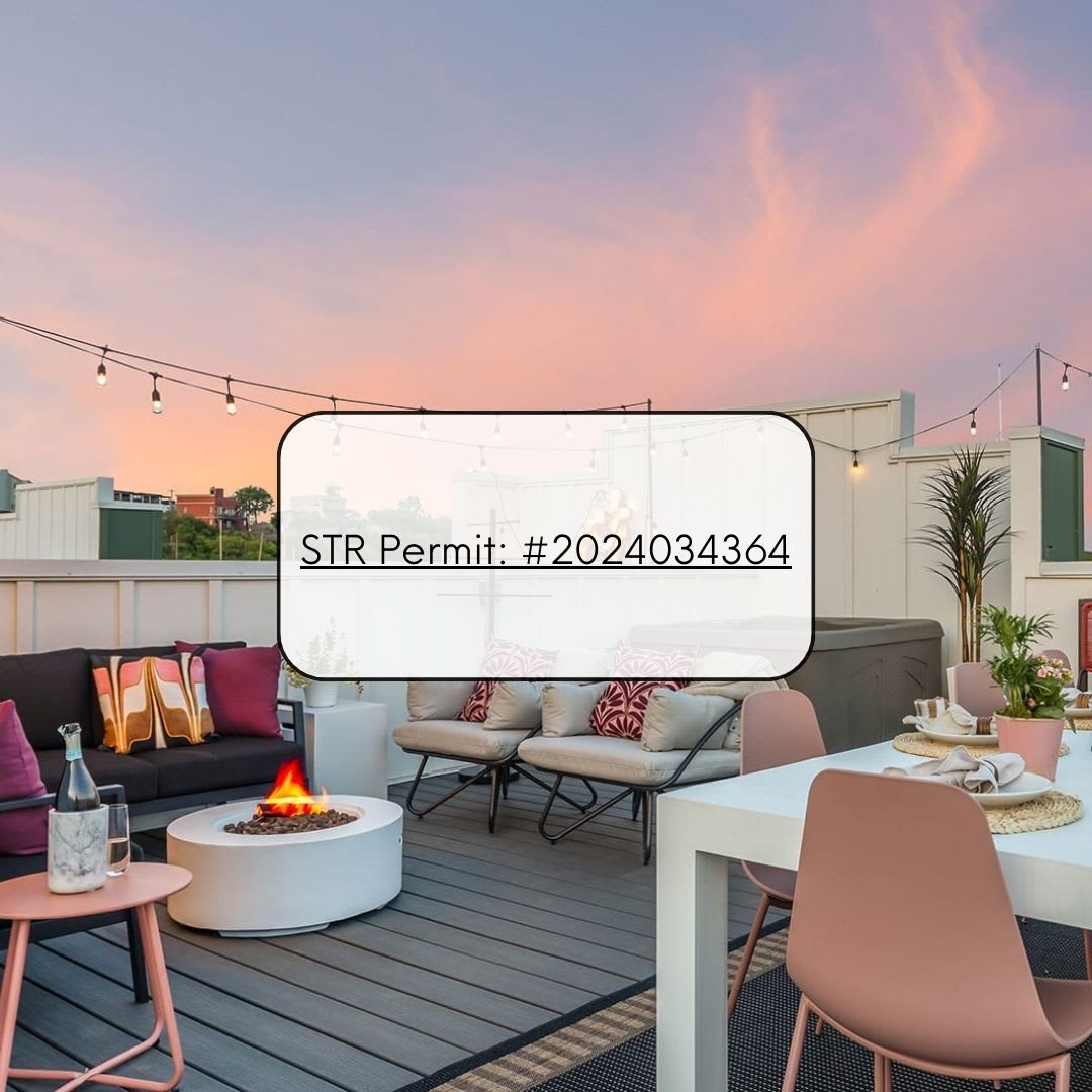 Rooftop deck with a white dining table, pink chairs, a lounge area with a black sofa, and a circular fire pit, under a sunset sky, with an 'STR Permit' overlay.