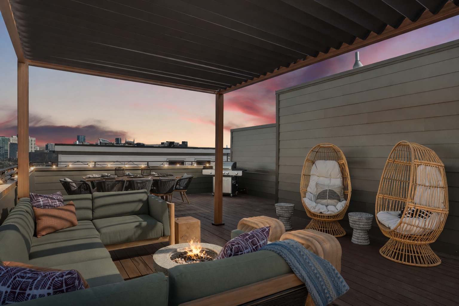 A spacious rooftop deck features a large L-shaped sectional sofa around a circular fire pit, a dining table for eight, and a BBQ grill, all under a modern slatted pergola with city views at sunset. Two woven egg chairs add a bohemian touch.