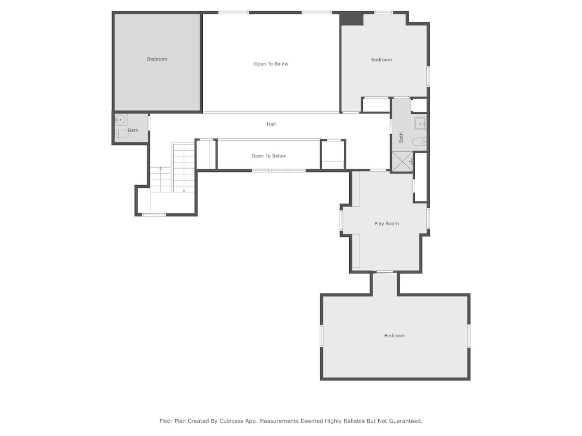 Upper level floor plan diagram showing three bedrooms, two bathrooms, a play room, and areas open to below, indicating a multi-story design. A central hall connects the spaces.