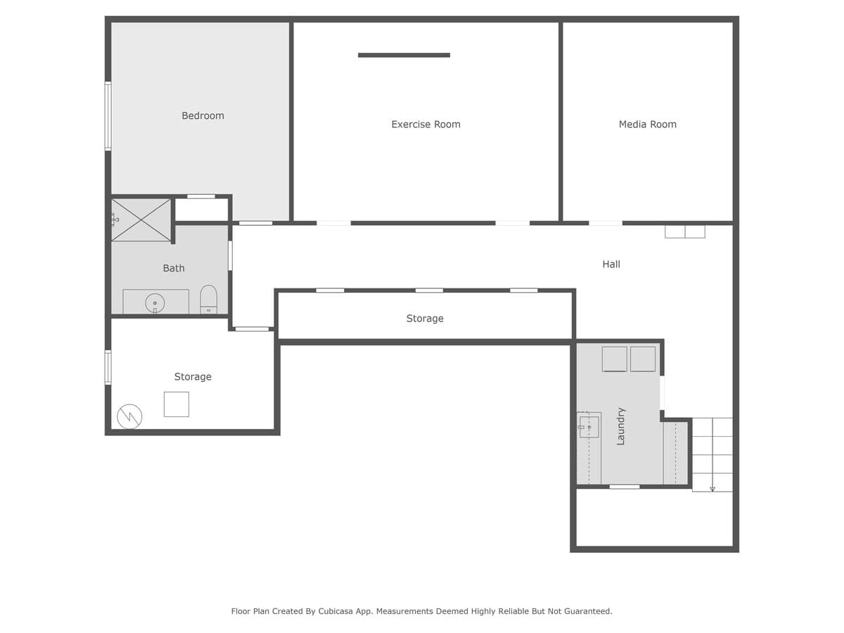 Basement floor plan diagram showing a bedroom, exercise room, media room, bath, storage areas, hall, and laundry room. The layout indicates distinct functional zones.