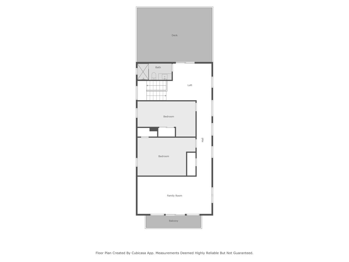 A detailed floor plan illustrating a long, narrow layout featuring a deck, a bathroom, a loft accessible by stairs, two distinct bedrooms, a central hall, a family room, and a balcony. The plan provides a clear overview of the property's internal structure and flow.