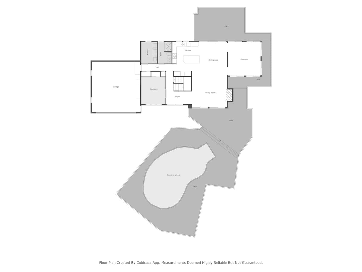 A detailed floor plan for the first level, illustrating the layout of a bedroom, garage, laundry, kitchen, dining area, living room, sunroom, and an outdoor deck with a swimming pool.