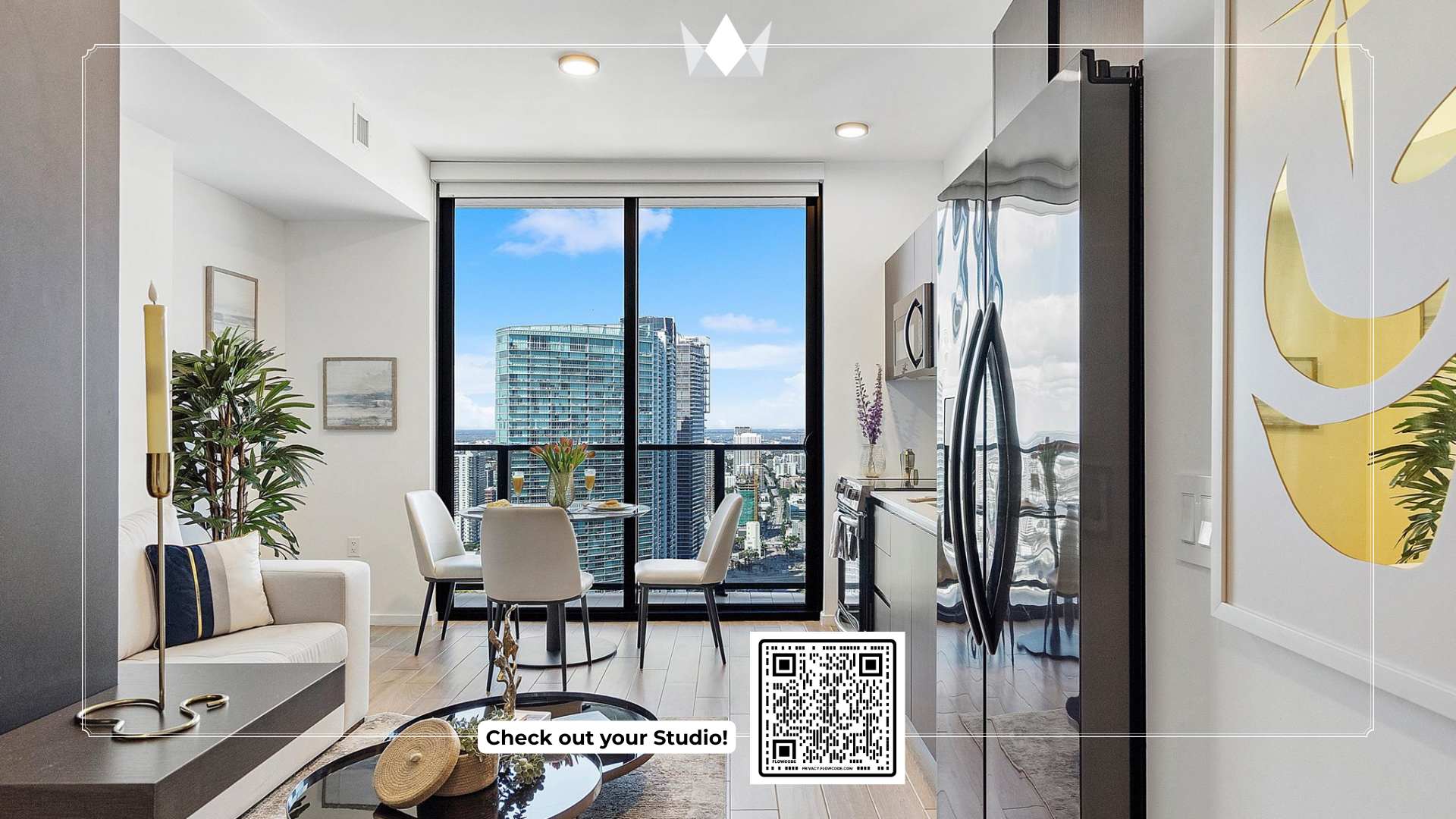 Bright studio living space with large windows offering panoramic city views, featuring a modern kitchen, a compact dining area, and a cozy seating arrangement with a sofa and coffee table. A QR code is overlaid on the image.