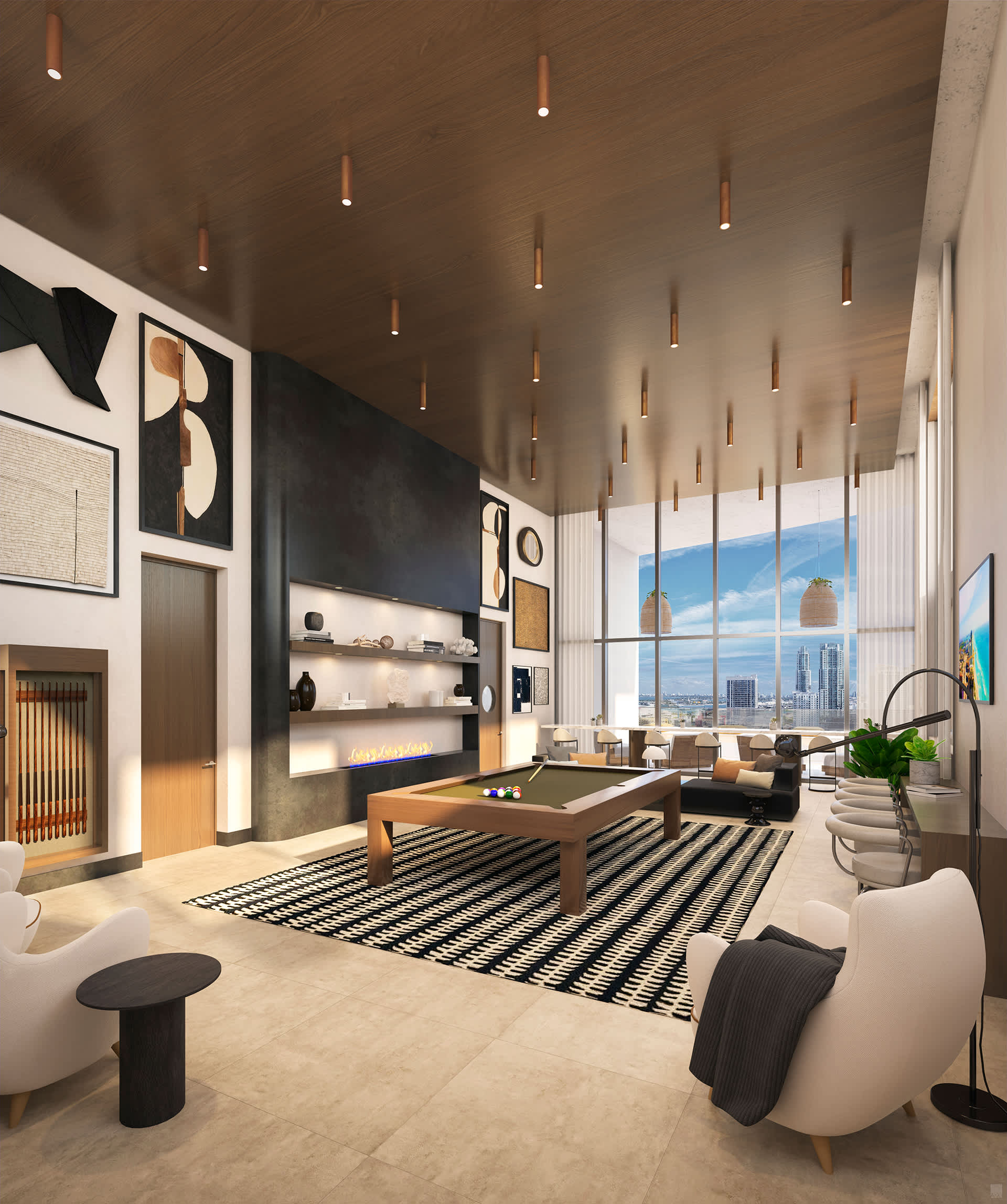 A stylish game room features a central pool table on a black and white striped rug, surrounded by comfortable armchairs and a long fireplace mantel, with large windows offering city views.