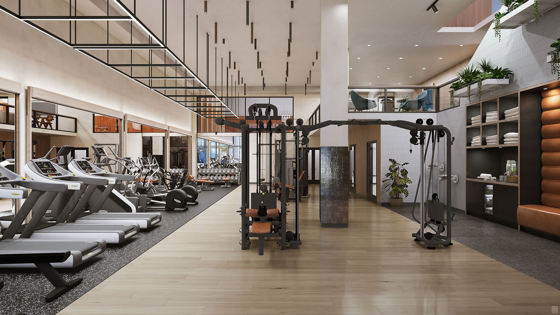A spacious and modern gym is equipped with various exercise machines including treadmills, weight machines, and free weights, featuring light wood floors and high ceilings with contemporary lighting.