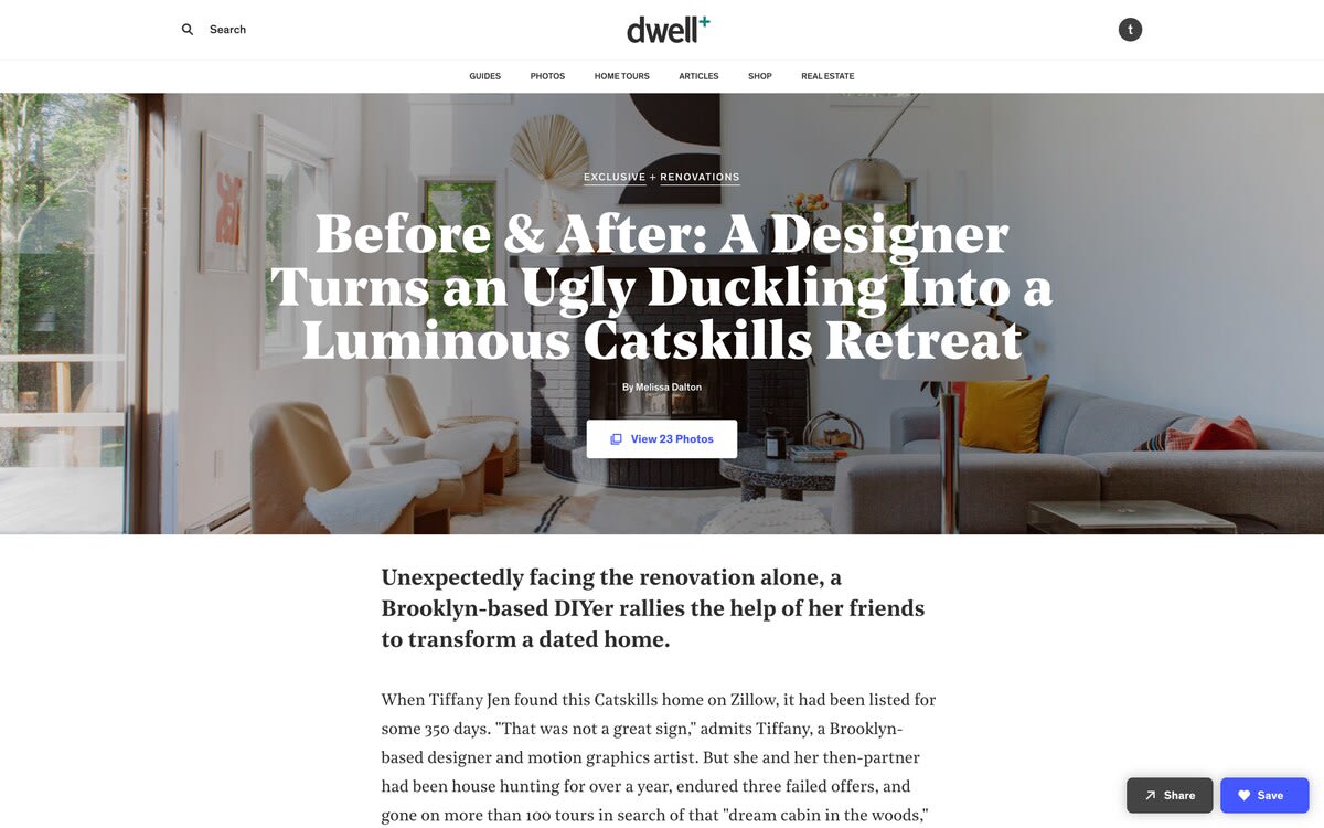 Dwell+ article screenshot featuring a bright, renovated living room with a modern fireplace, a light grey sofa, two armchairs, and large windows overlooking greenery.