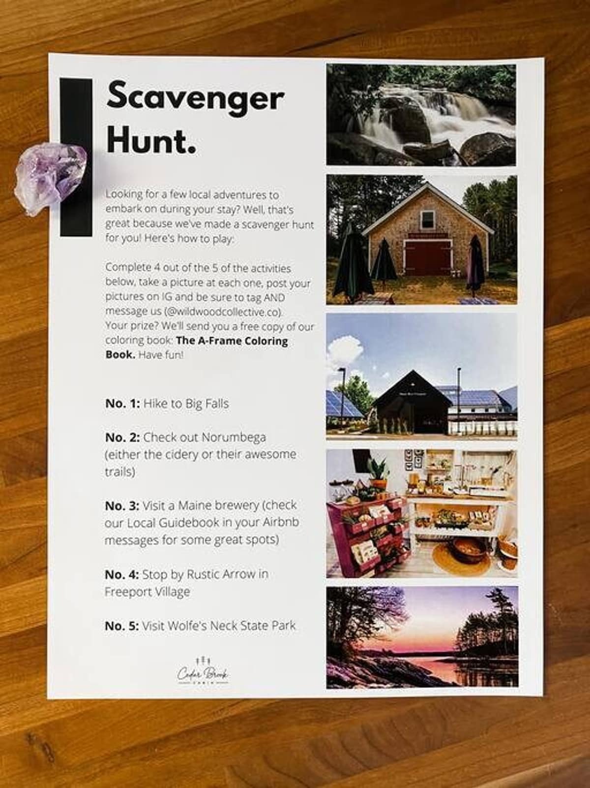 A printed "Scavenger Hunt" sheet details five local activities, accompanied by small scenic photographs of waterfalls, a barn, a brewery, and a coastal sunset. A purple crystal sits on the paper.