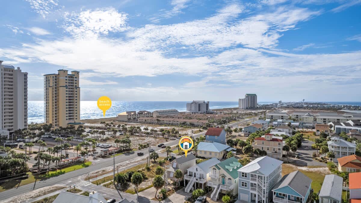 Aerial view of a coastal neighborhood with an overlay highlighting the property's location and nearby beach access, showing residential homes, high-rise buildings, and the ocean.