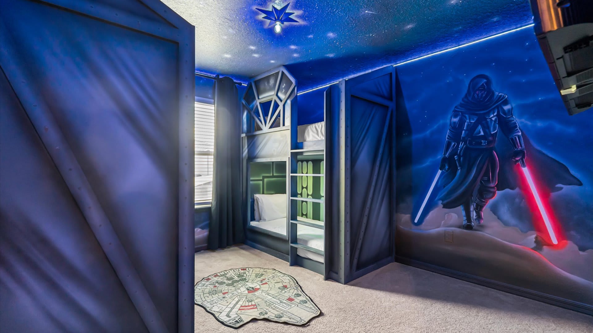 Star Wars themed bedroom with custom-built bunk beds designed like spaceship interiors, a large mural of Darth Vader with a red lightsaber, and a Millennium Falcon rug on the carpeted floor.