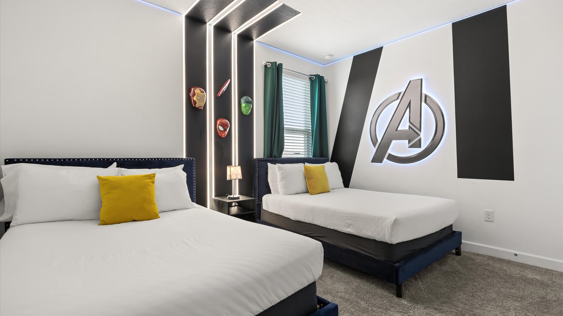 Dynamic Avengers-themed bedroom with two twin beds, a large illuminated Avengers logo on the wall, and a black accent wall with vertical lighting strips. Green curtains add a pop of color.