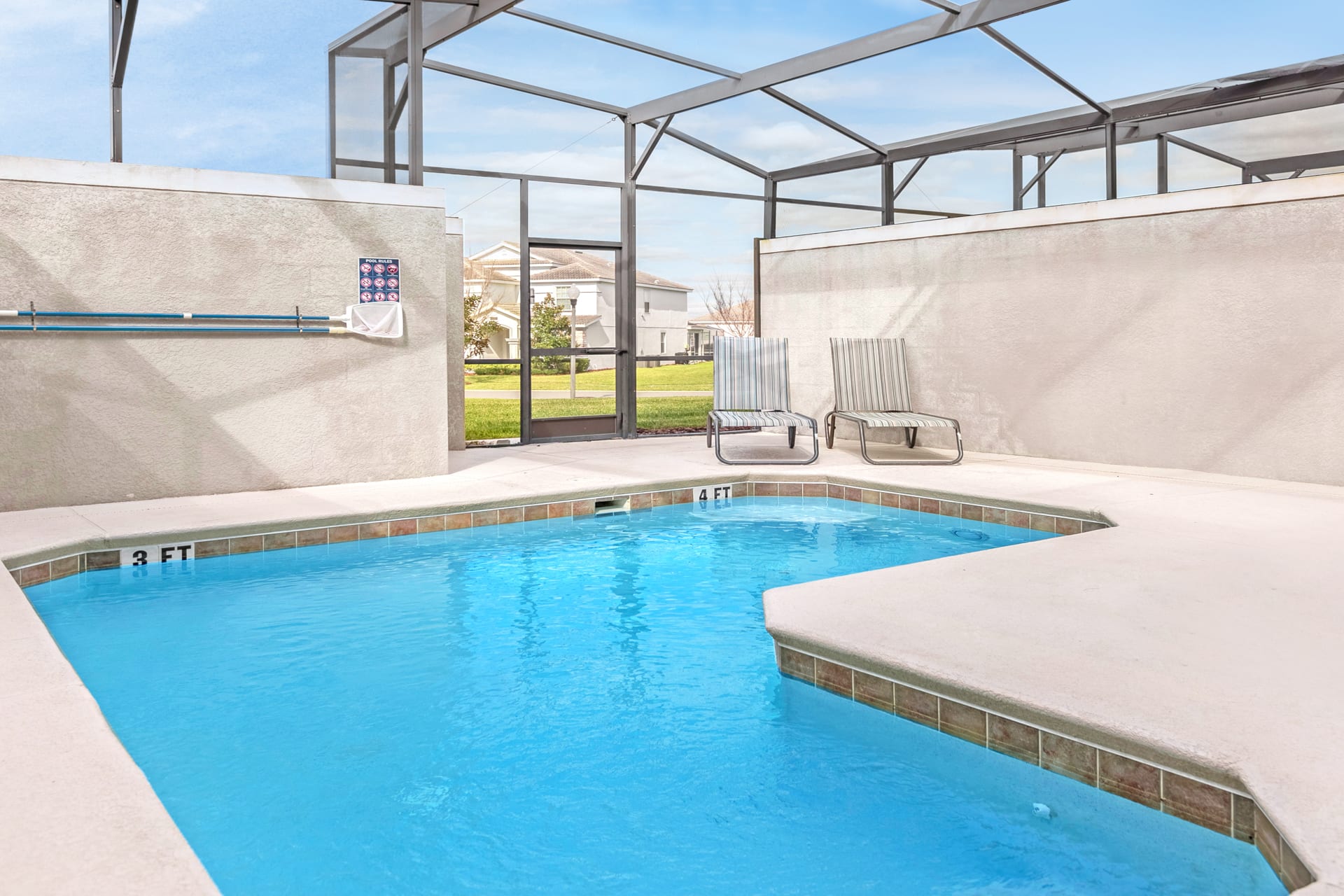Close-up view of the private screened pool, showing the 3 ft and 4 ft depth markers. Two lounge chairs are visible outside the pool area, within the screened enclosure.