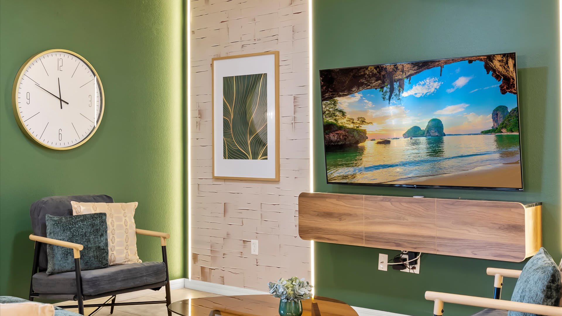 A modern living space featuring green accent walls, a large wall-mounted TV, a floating wooden media console, and contemporary armchairs with decorative throw pillows.