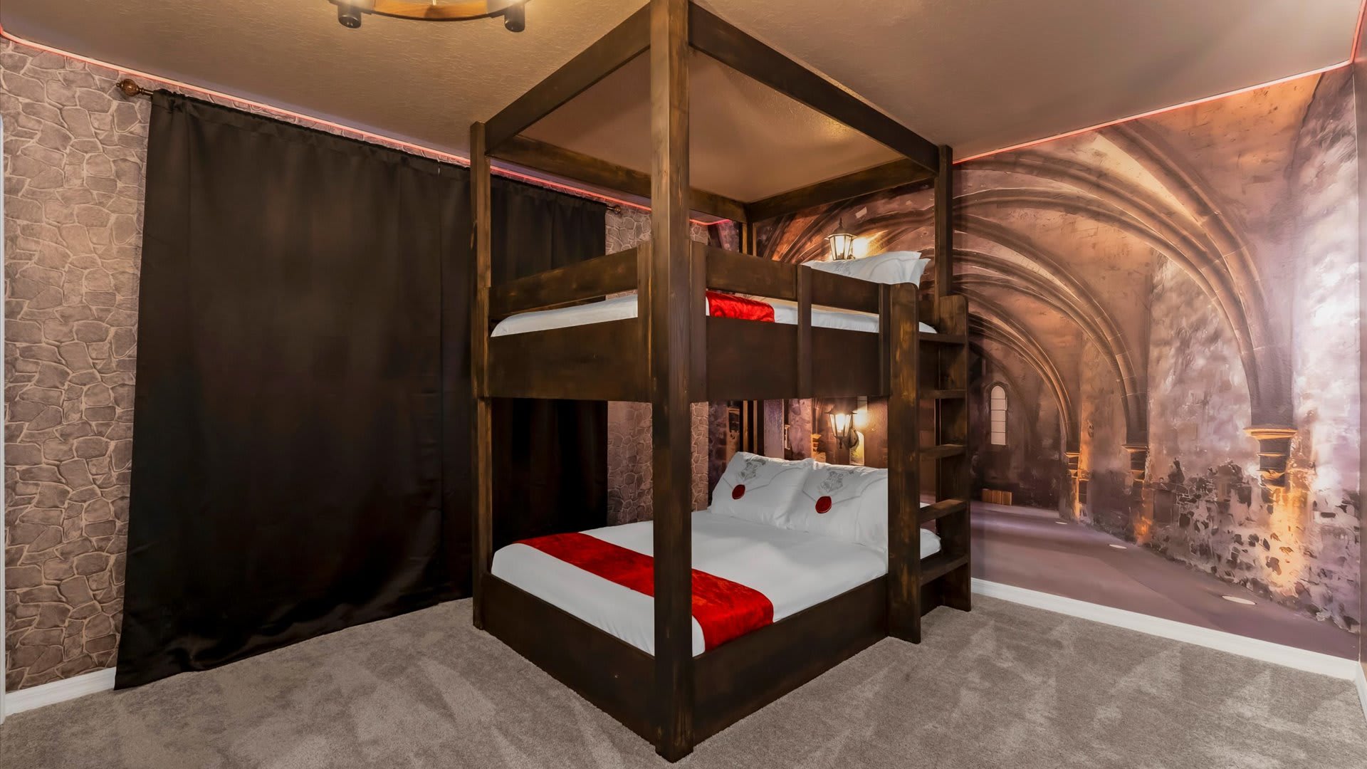 A Harry Potter-themed bedroom with a dark wooden bunk bed featuring red accents on the bedding. The wall is adorned with a mural depicting a stone archway or dungeon, illuminated by warm lighting.