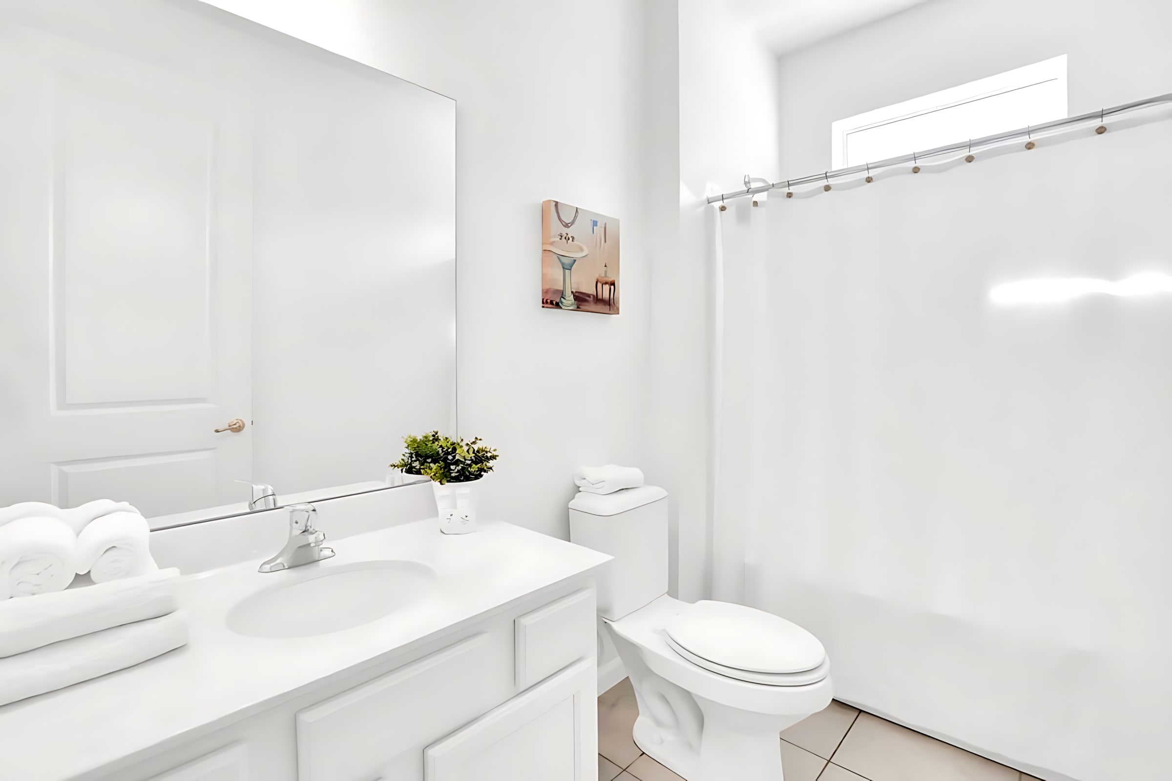 Clean white bathroom with a single vanity, large mirror, toilet, and a shower/tub combo with a plain white shower curtain, accented by a small plant.