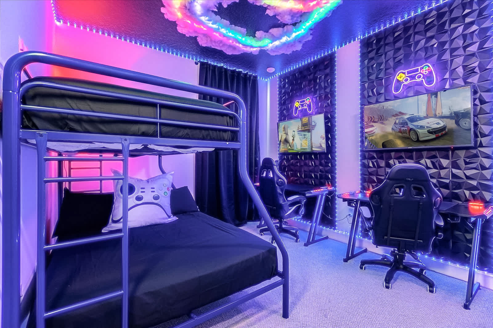 Vibrant game room with a black metal bunk bed, two dedicated gaming stations featuring monitors and ergonomic chairs, and geometric wall panels. Neon lights illuminate the space.