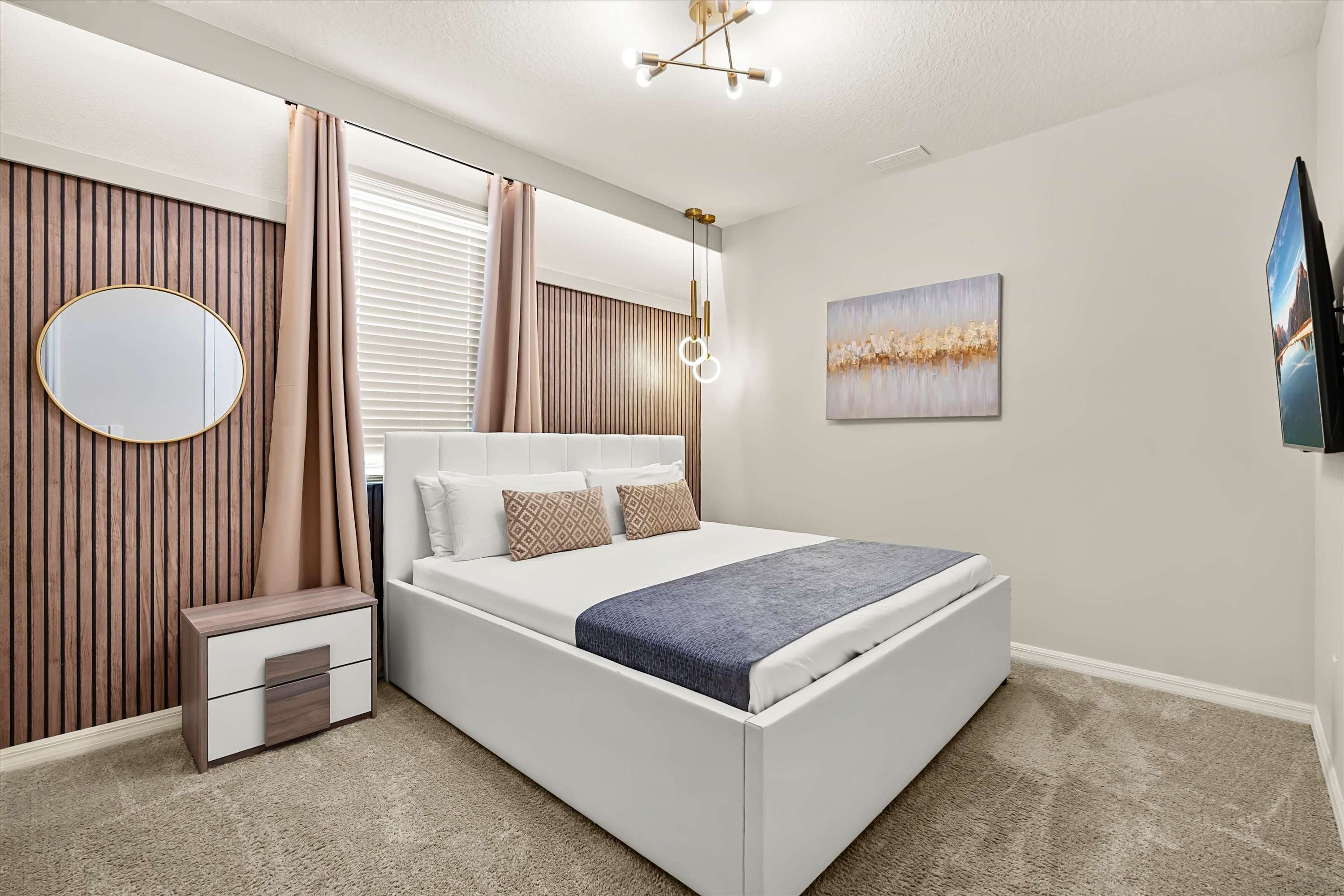 Modern bedroom featuring a white platform queen bed with neutral bedding, a textured wood-slat accent wall, and a contemporary gold light fixture.