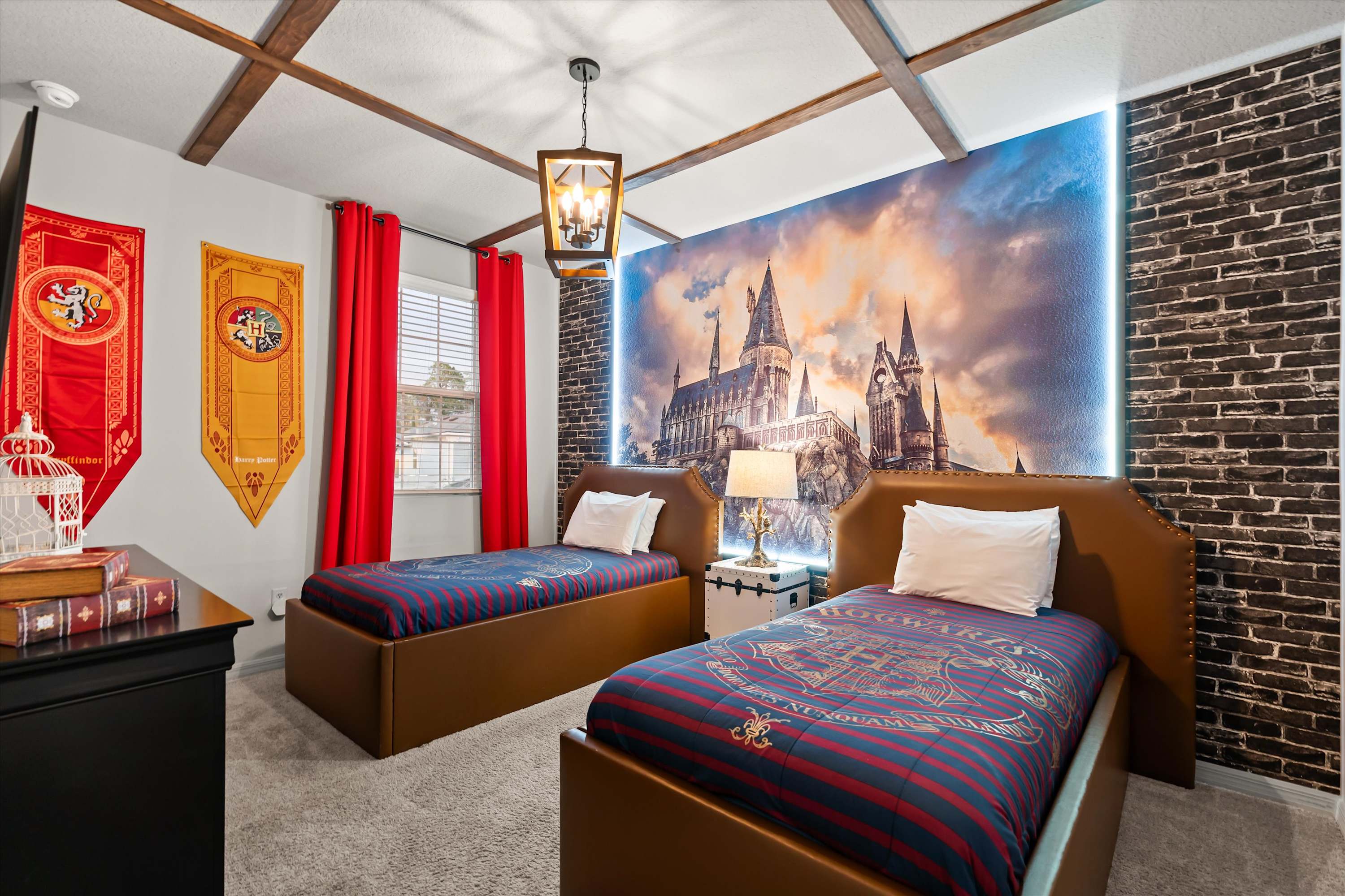 Harry Potter-themed bedroom featuring two twin beds with brown leather headboards, a large Hogwarts castle mural with LED lighting, and a ceiling with decorative wooden beams.