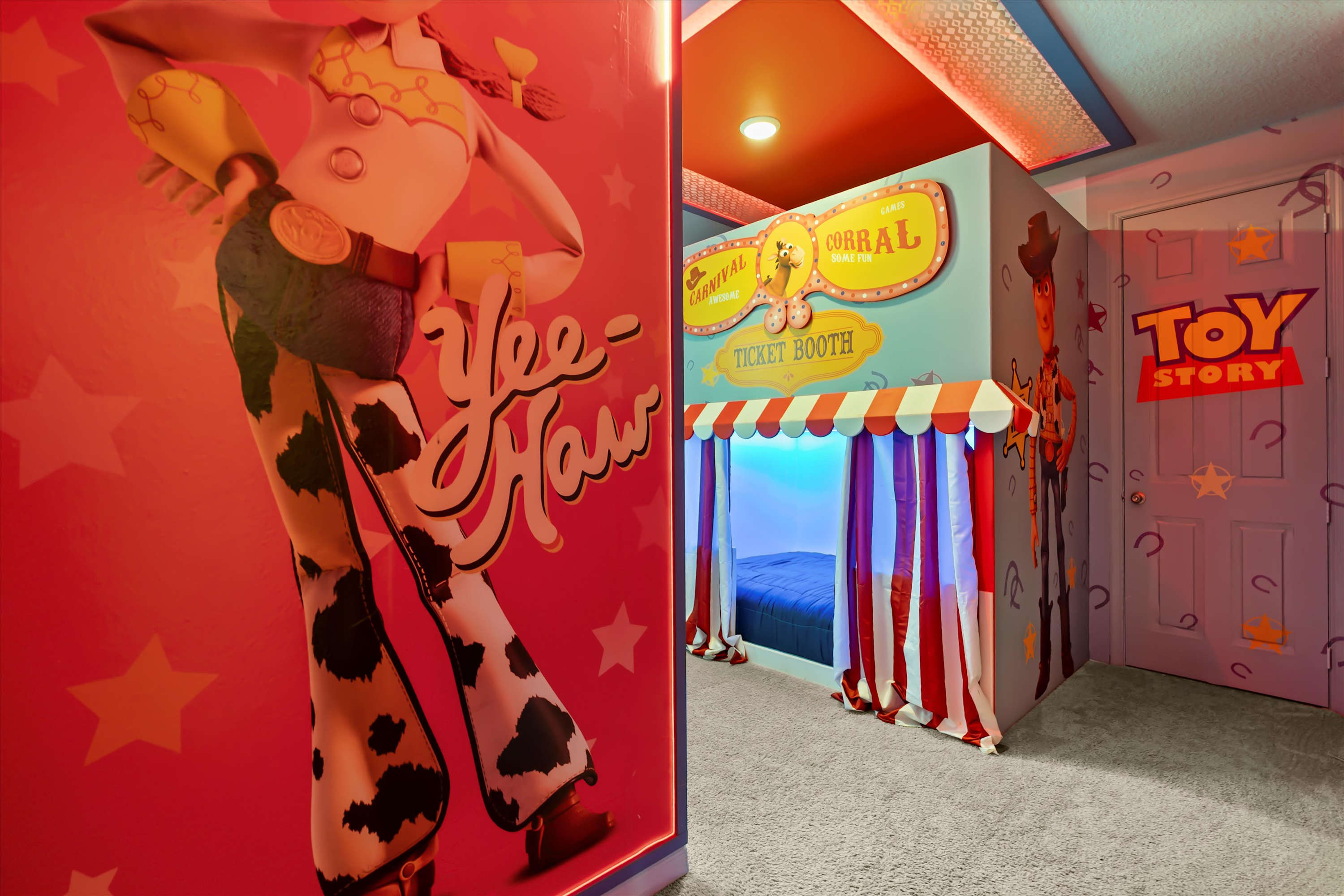 Immersive Toy Story themed bedroom with a large Jessie mural on the left, a carnival-style bed enclosure, and a "Toy Story" themed door, all illuminated by colorful ambient lighting.