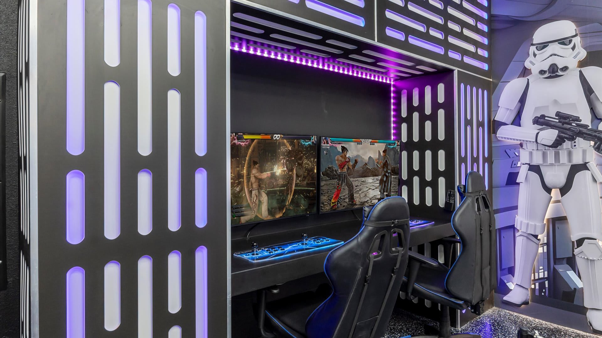 A dedicated gaming station features two screens displaying fighting games, with two black gaming chairs and joysticks, all set within a Star Wars-themed alcove with purple LED lighting and a Stormtrooper figure nearby.